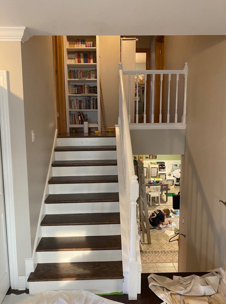 Staircase with white painted railing and trim and dark wood treads